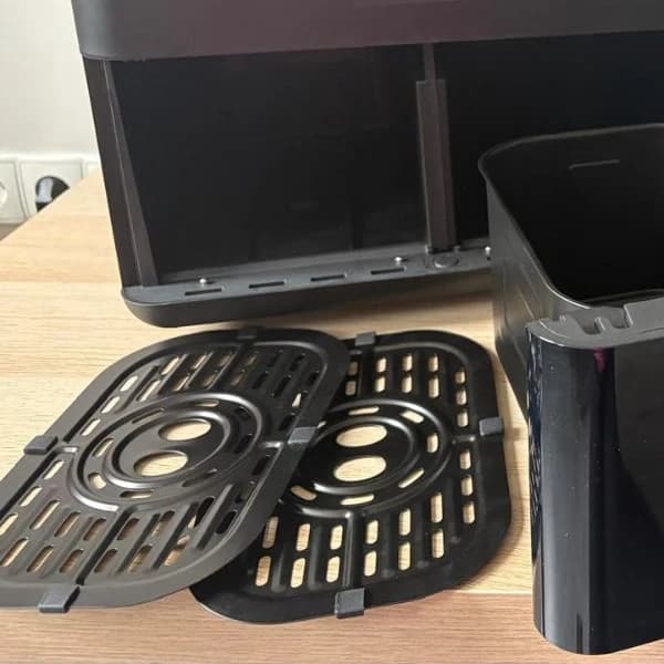 The two racks and the empty basket compartments of the air fryer
