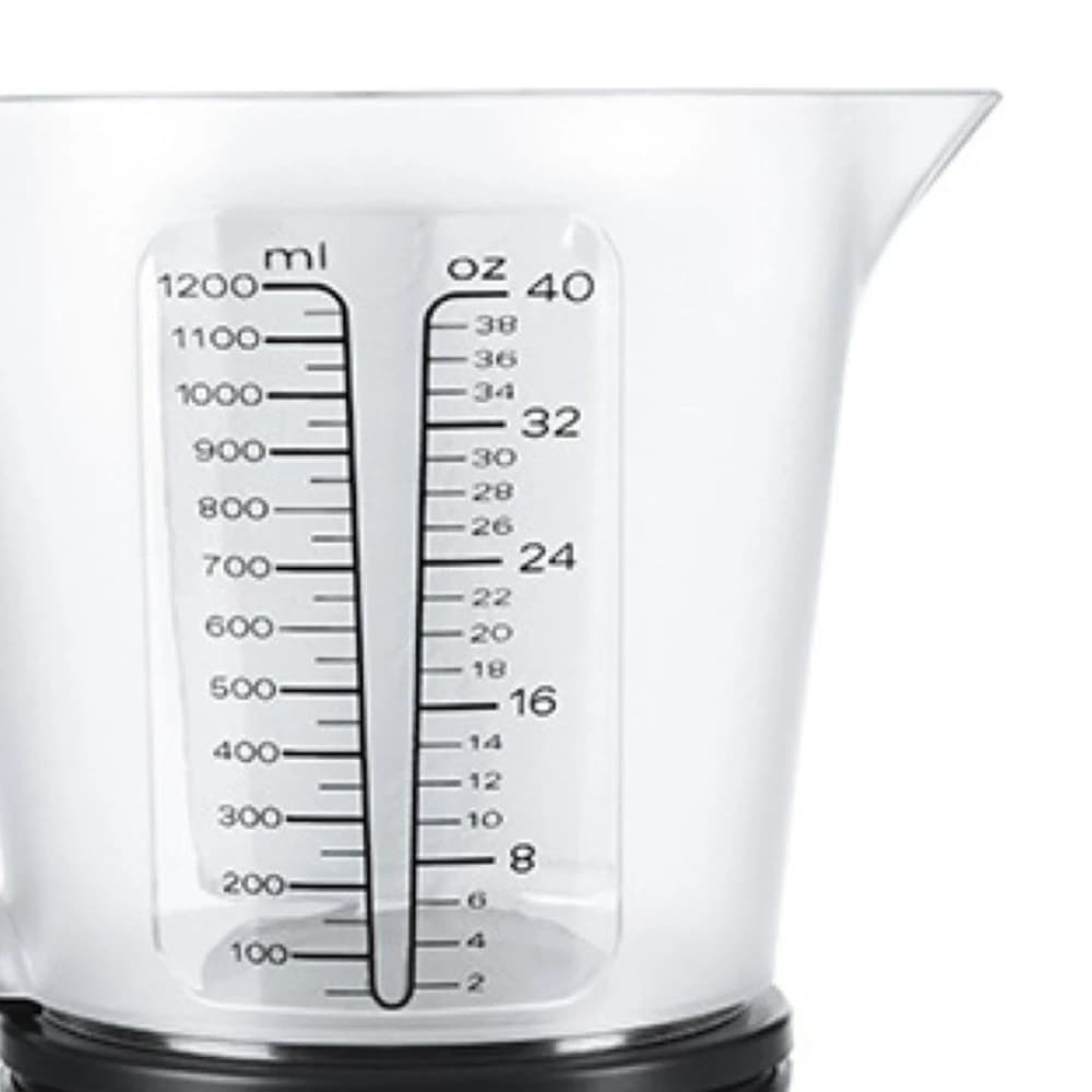 The measuring jug from the front, with its spout and the millilitre and ounce markings